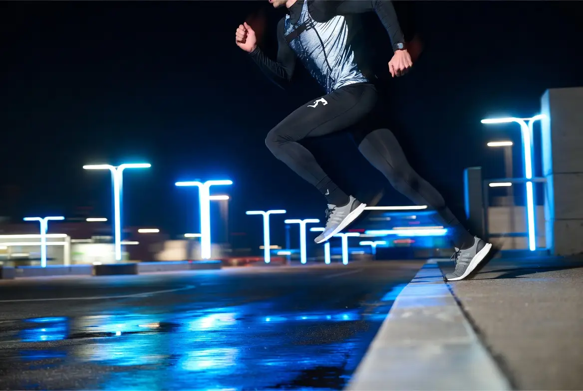 A nighttime sports campaign frame featuring dynamic movement and dramatic urban lighting.